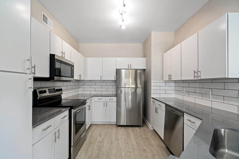 a kitchen with white cabinets and stainless steel appliances