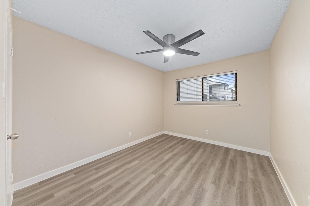 a bedroom with hardwood floors and a ceiling fan