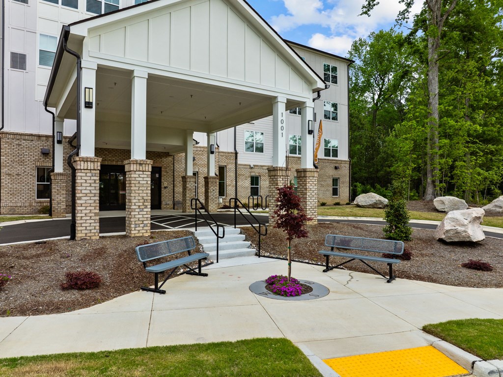 a building with a porch and benches in front of it