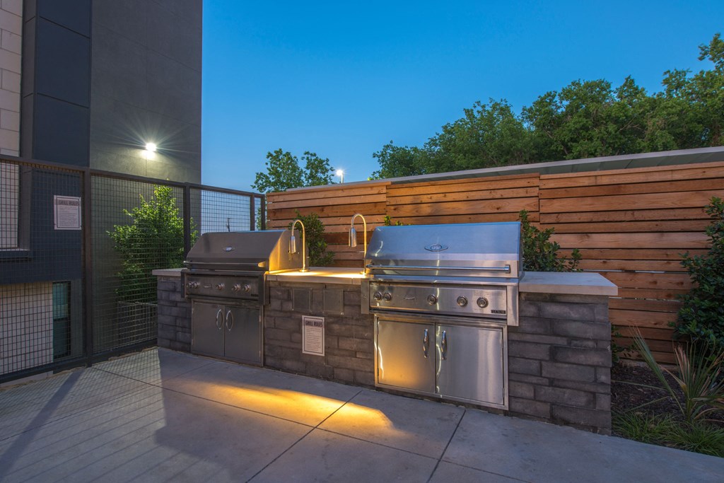 a stainless steel barbecue grill on a patio in the evening