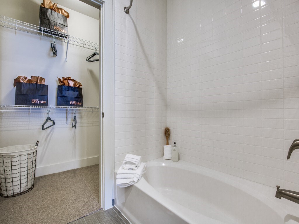 a bathroom with a tub and a shower and white tiles