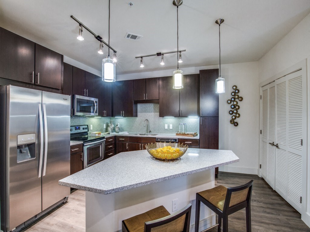 a kitchen with stainless steel appliances and a marble counter top
