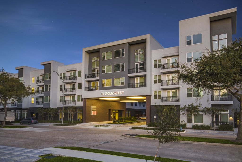 an apartment building with a street at night