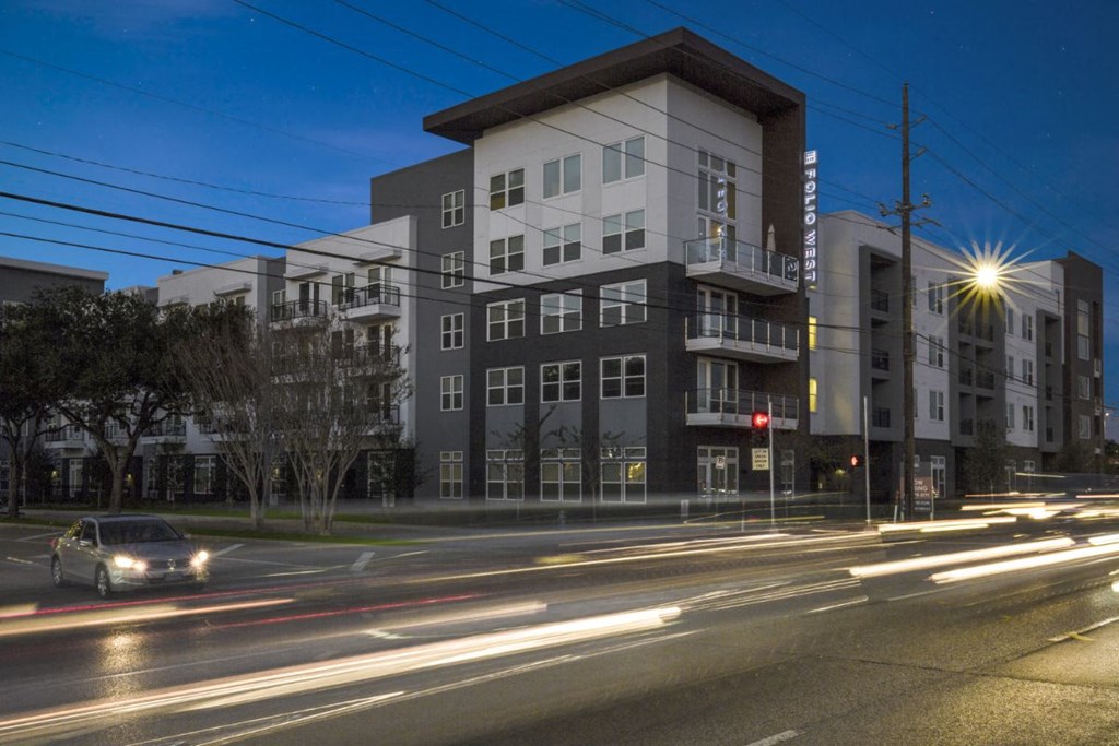 an apartment building on a city street at night