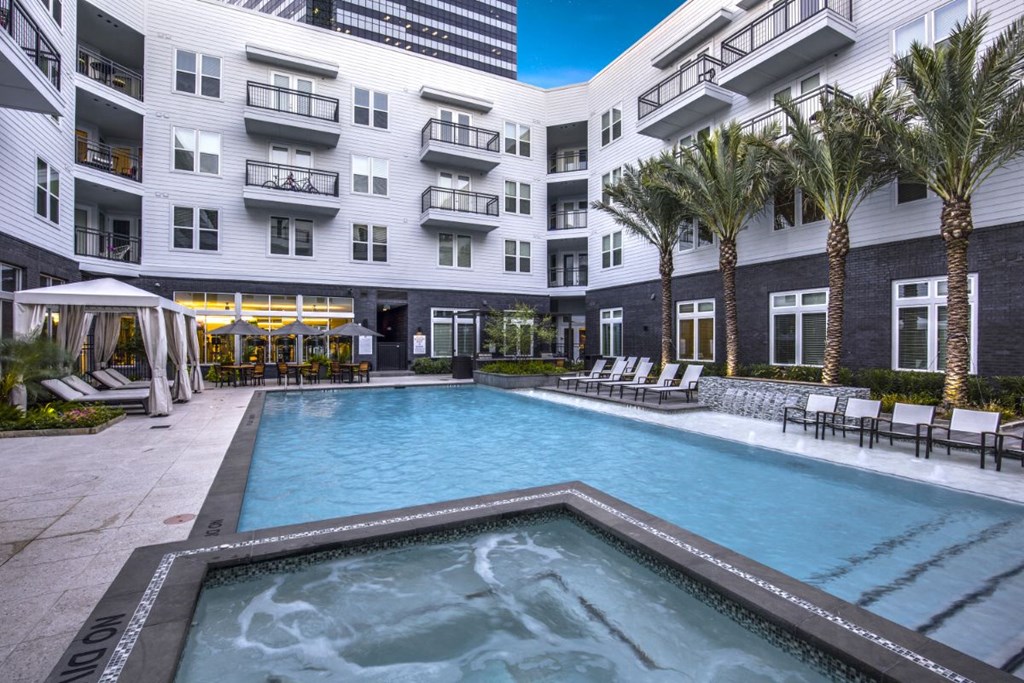 a large swimming pool in front of an apartment building