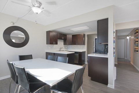 a kitchen and dining room with a white table and black chairs