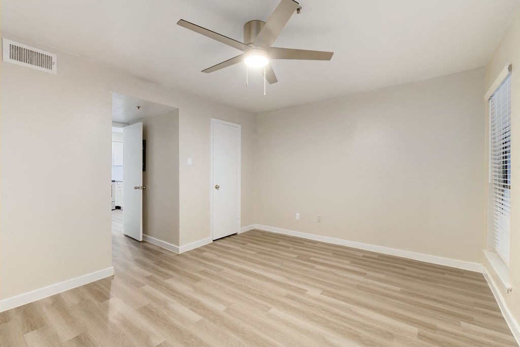 a bedroom with hardwood floors and a ceiling fan