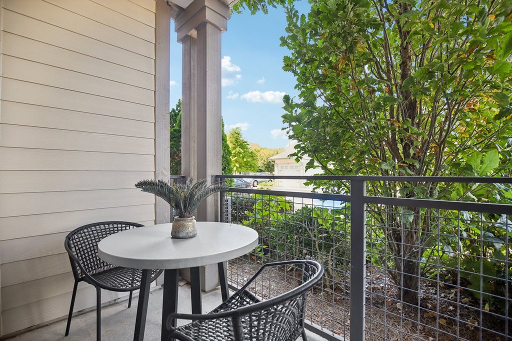 A patio with a table and chairs overlooking a street.