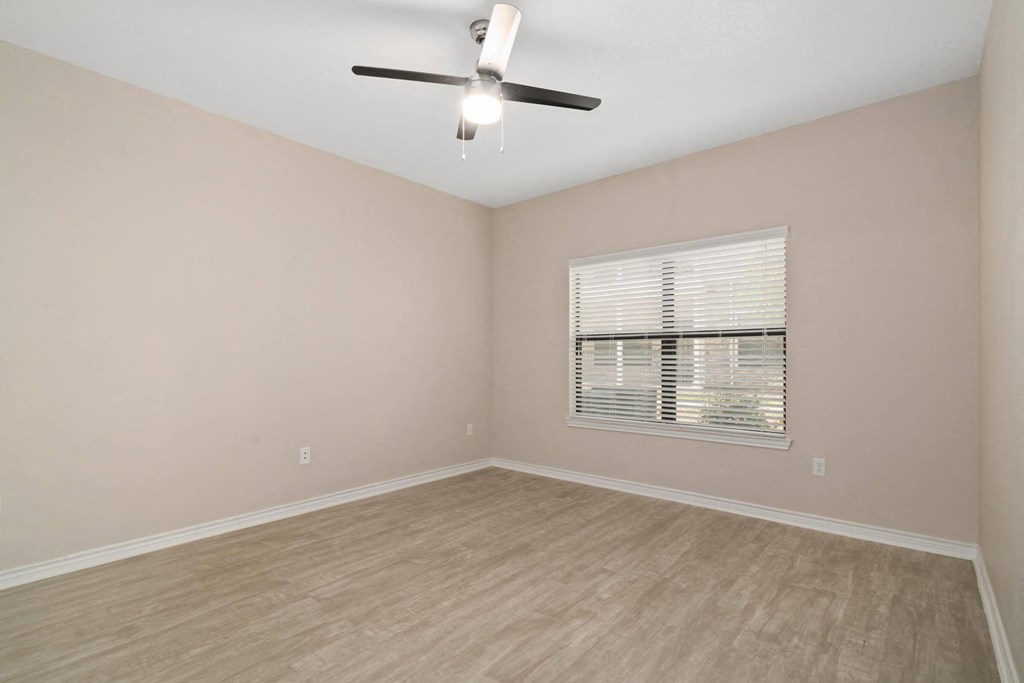 a bedroom with a ceiling fan and a window