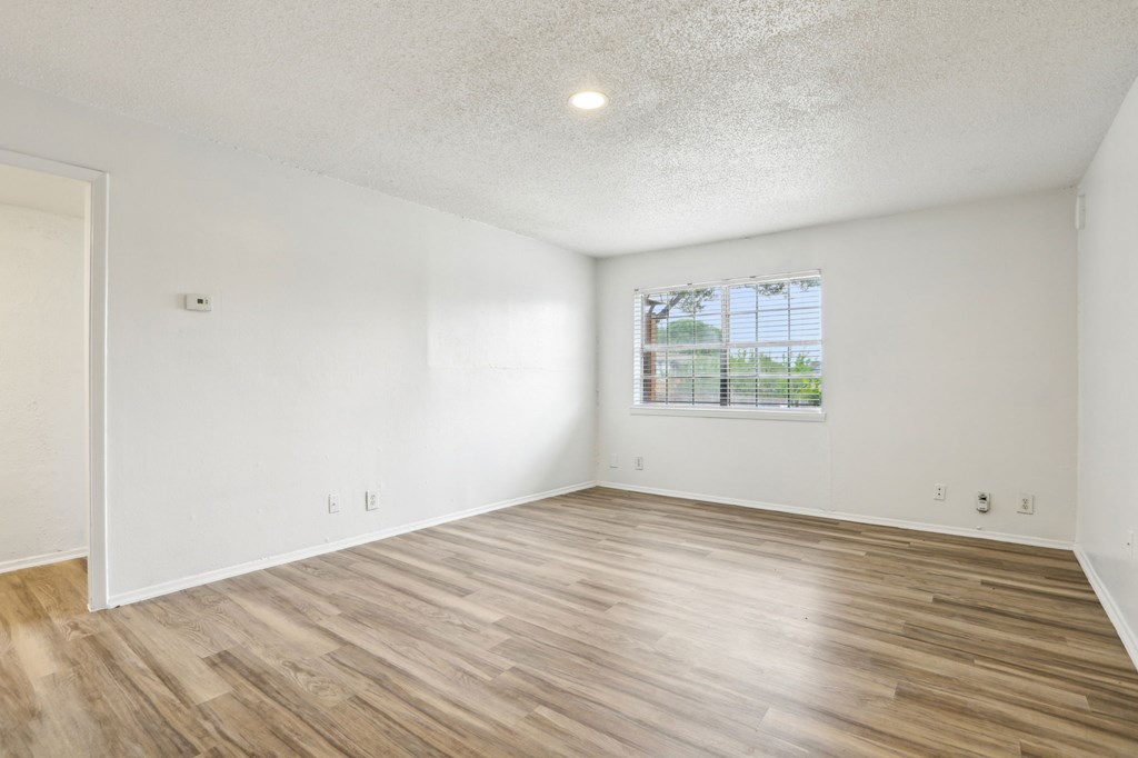 A room with wooden flooring and a window.