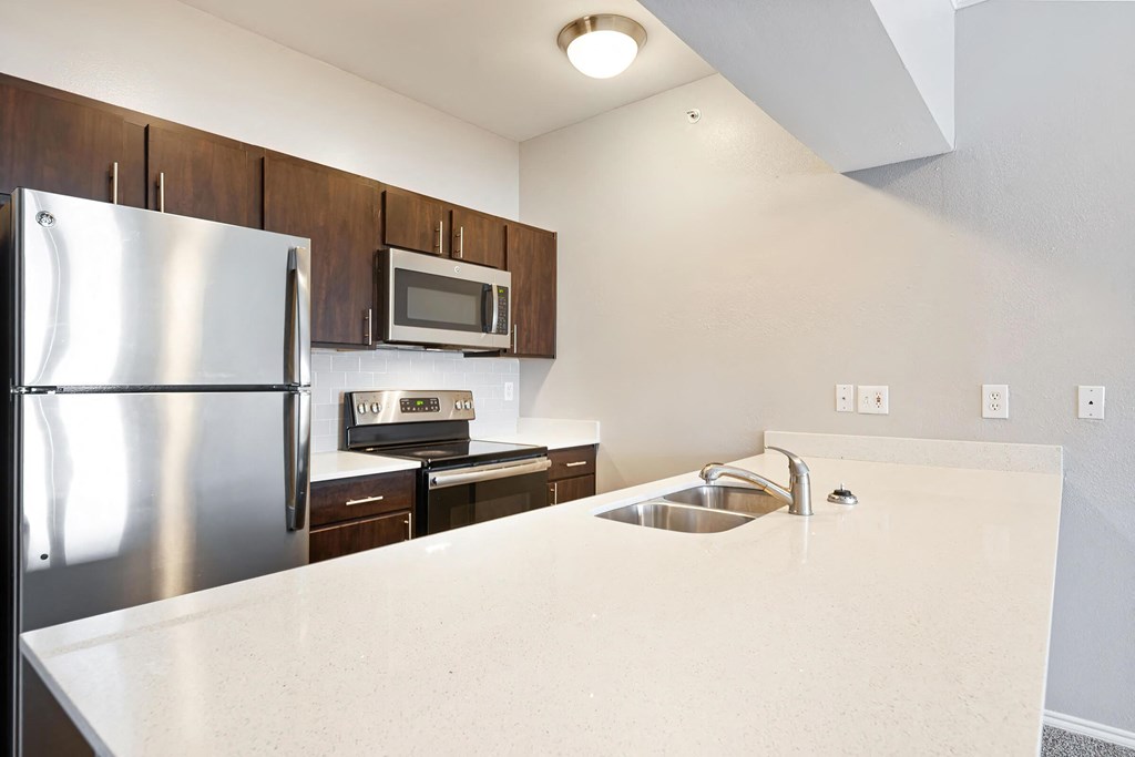 a kitchen with white countertops and wooden cabinets