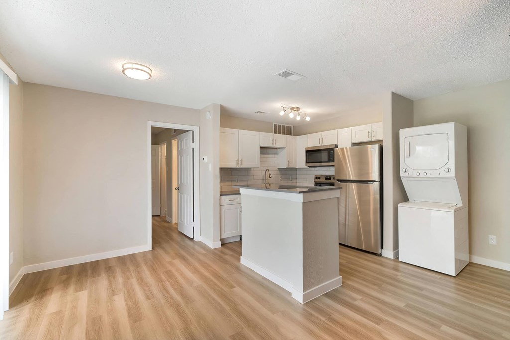 a kitchen with white cabinets and a white washer and dryer