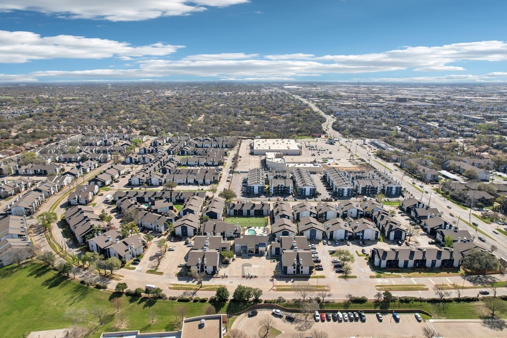 A bird's eye view of a residential area with houses and a parking lot.