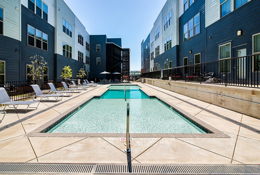 a swimming pool is between two modern apartment buildings