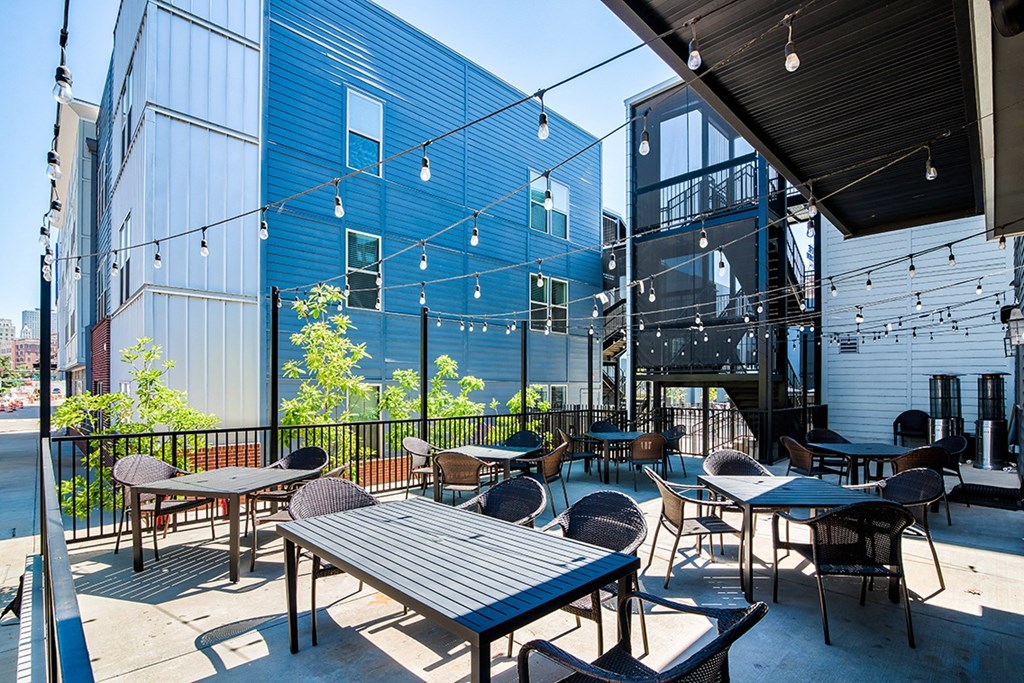 a patio with tables and chairs outside of a blue building