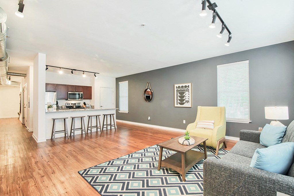 a living room with a couch and a table in front of a kitchen