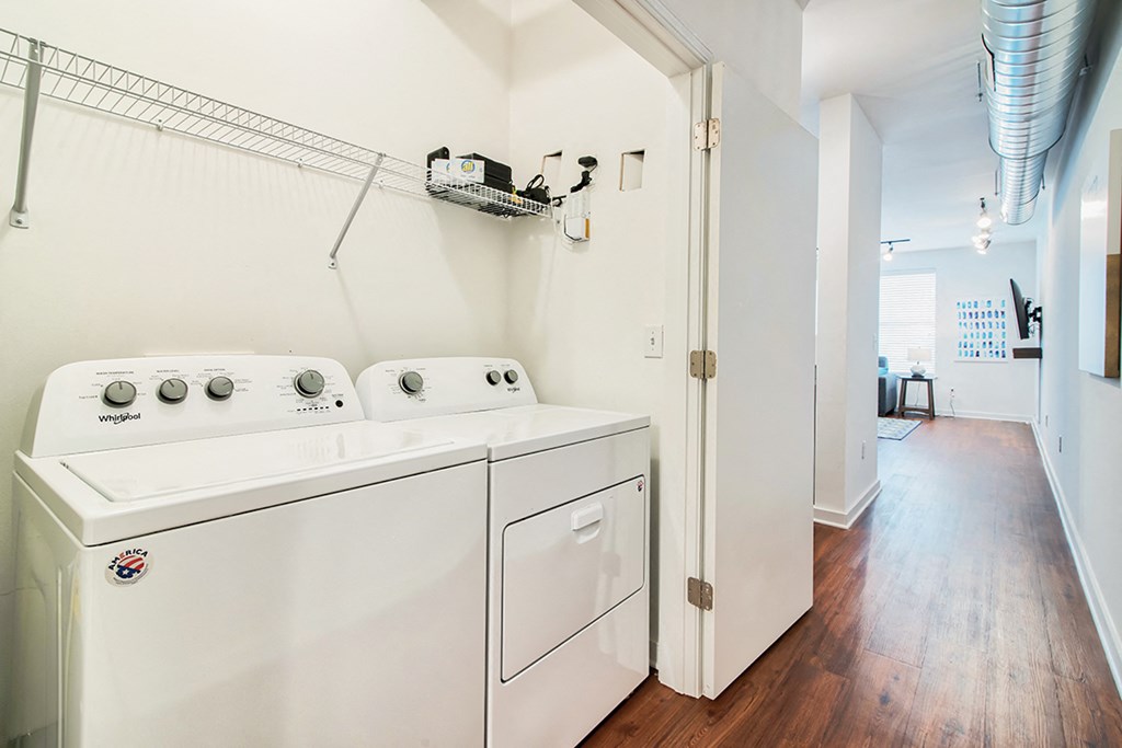 a washer and dryer in a room with a hallway and a laundry room