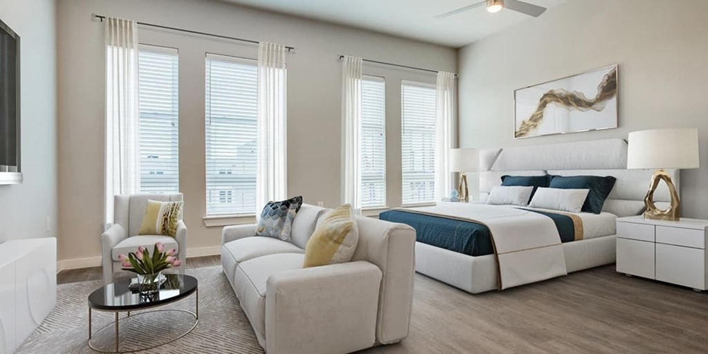 A modern bedroom with a large bed, a sofa, and a coffee table.