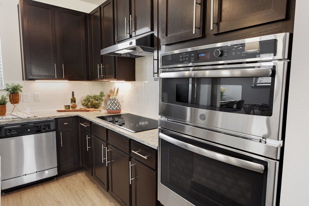 a kitchen with stainless steel appliances and dark wood cabinets