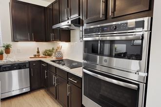 a kitchen with stainless steel appliances and dark wood cabinets