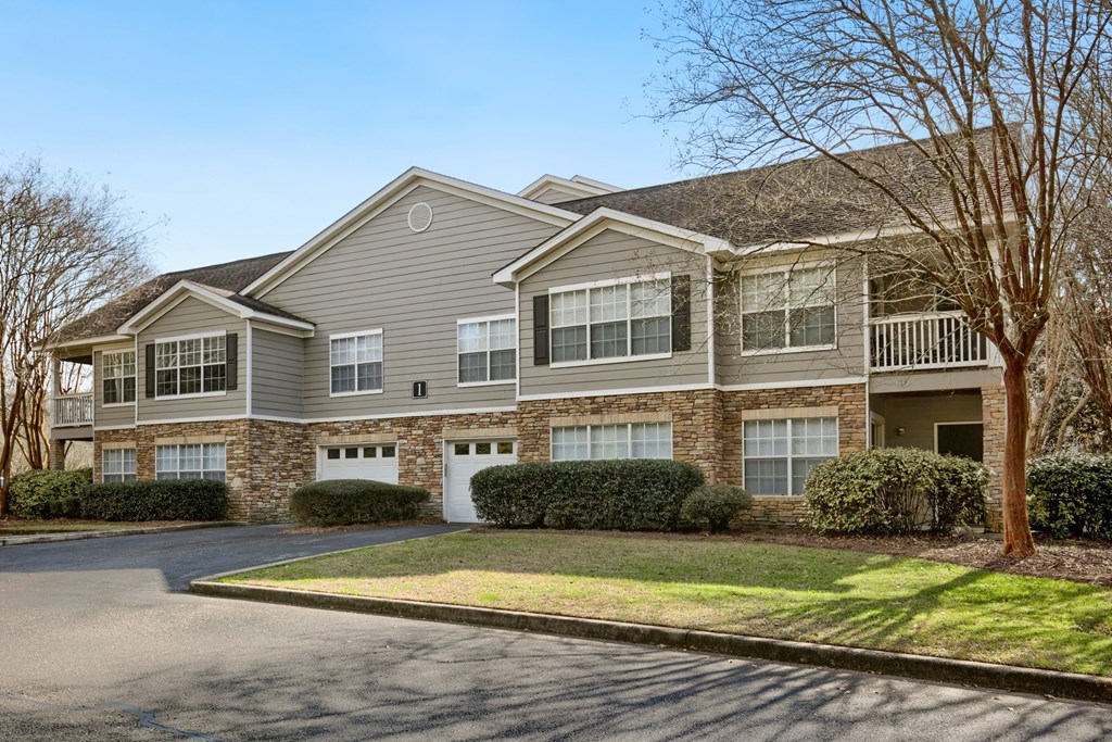 a house with a driveway and lawn in front of it