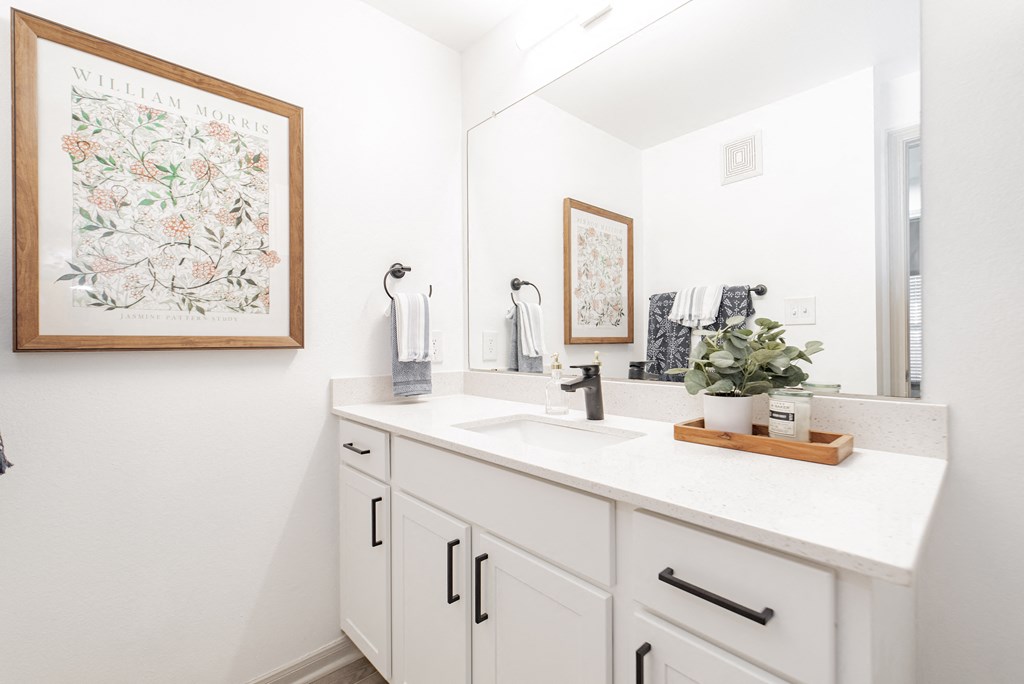 a white bathroom with a sink and a mirror