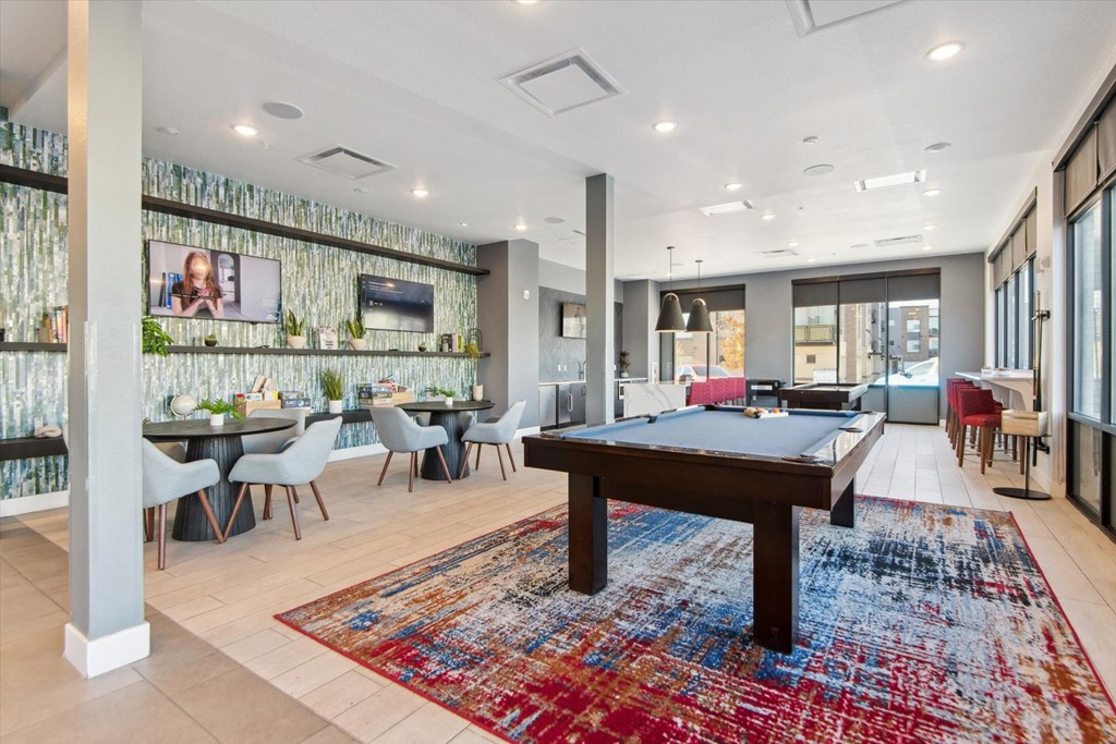 A room with a pool table and a TV mounted on the wall.