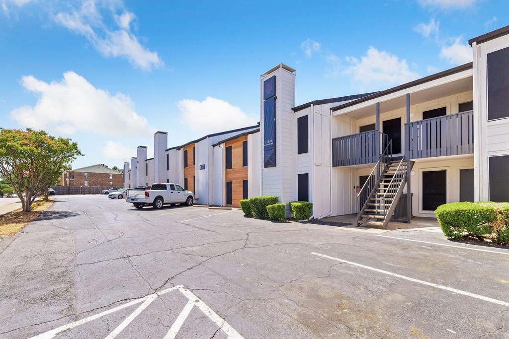 an empty parking lot in front of an apartment building