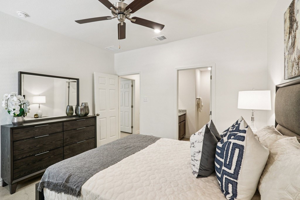 A bedroom with a bed, dresser, and mirror.