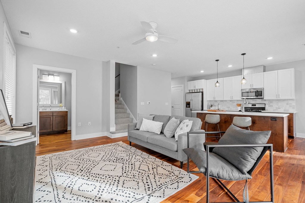 a living room with a couch and a chair and a kitchen