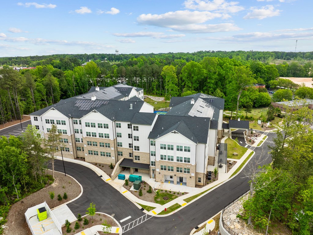 an aerial view of an apartment complex with trees in the background