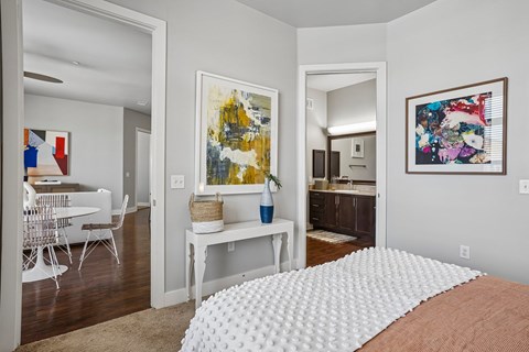 A bedroom with a large bed and a painting on the wall.