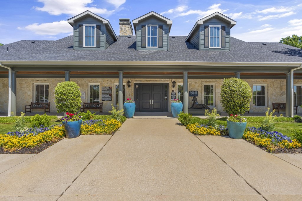 the front of a house with a driveway and a black door