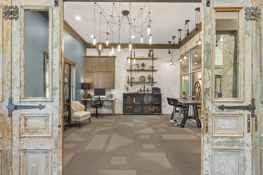the lobby of a building with doors open to a room with a table and chairs