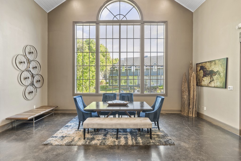 a dining room with a large window and a table and chairs