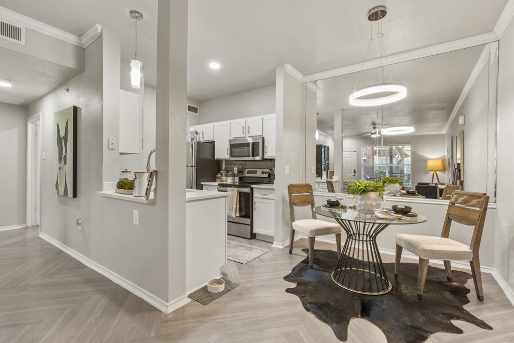 a dining room and kitchen area with a table and chairs