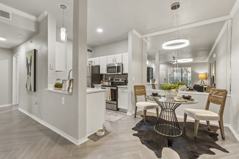 a dining room and kitchen area with a table and chairs