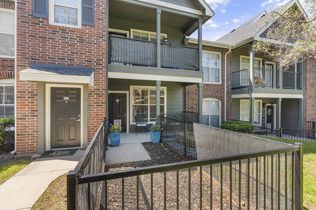 an apartment building with a balcony and a sidewalk