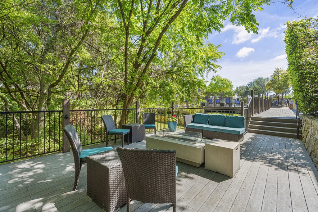 a deck with chairs and a table and trees
