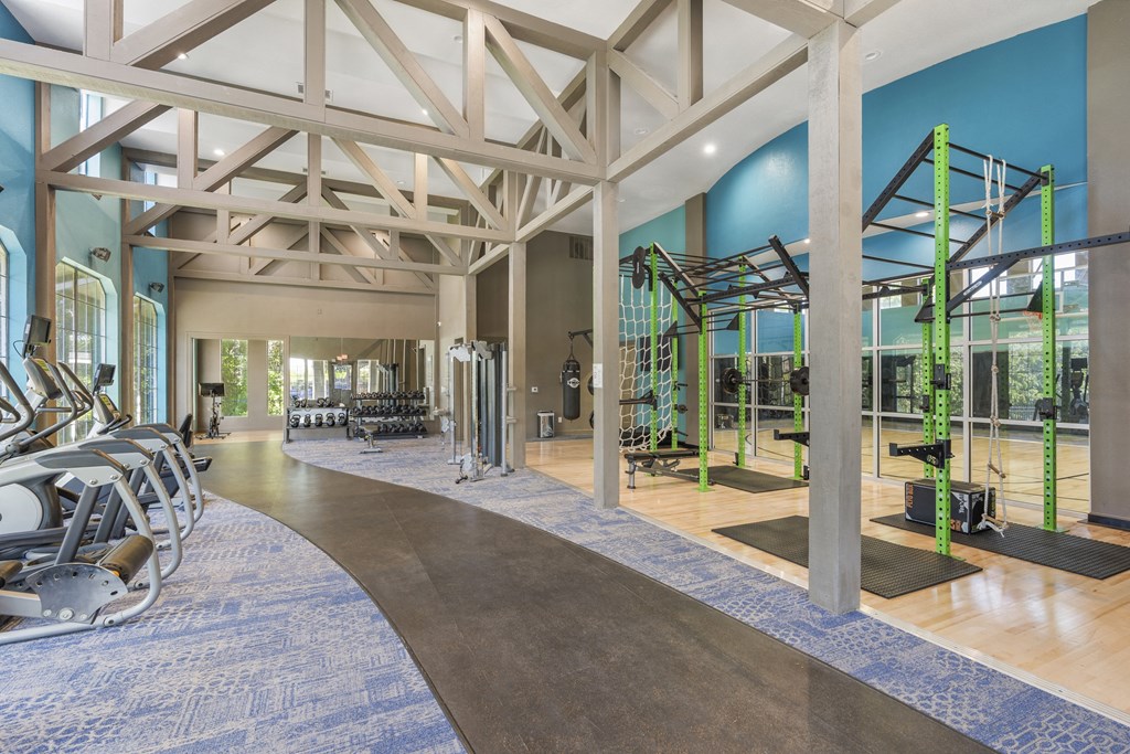 a gym with weights machines and other equipment in a building with blue walls