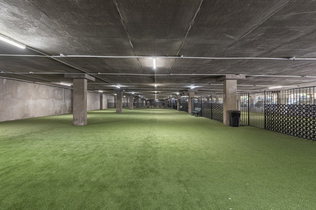 a large empty room with green grass on the floor