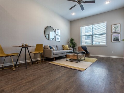 A living room with a yellow chair and a beige couch.