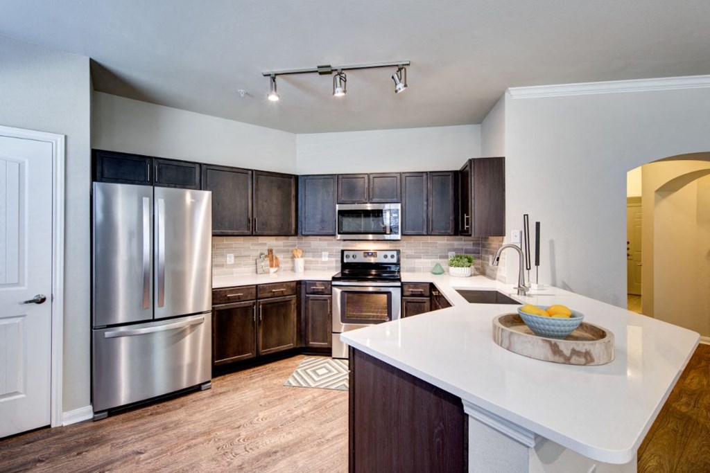 a kitchen with stainless steel appliances and a white counter top
