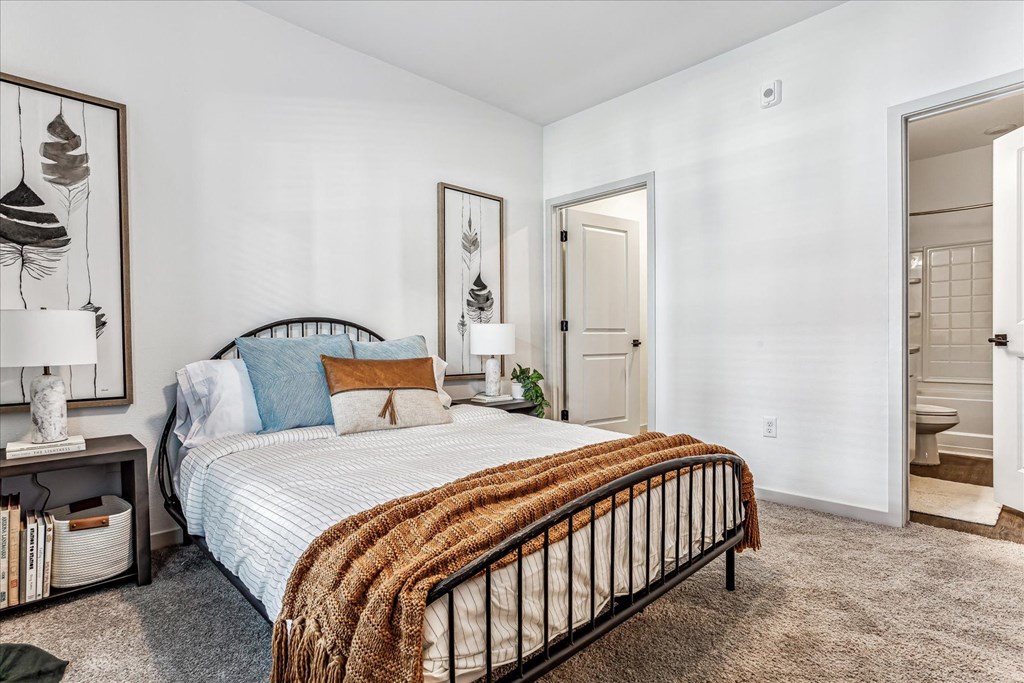 a bedroom with a bed and a door to a bathroom