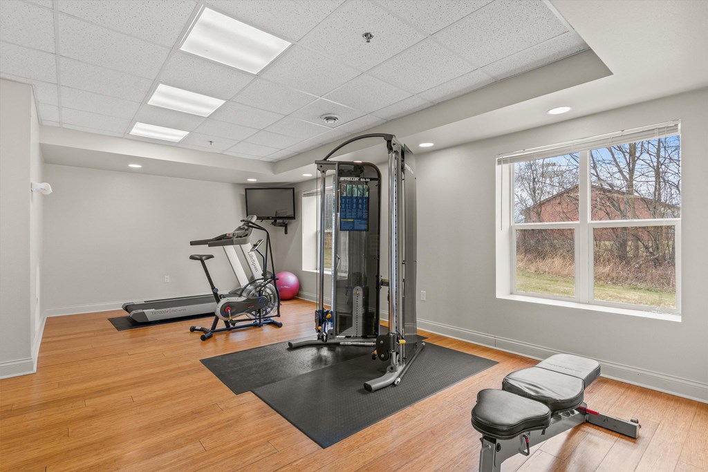 a home gym with exercise equipment and a window