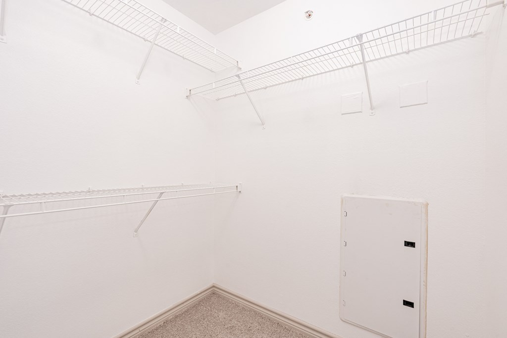 a white room with white shelves and a white door on the wall