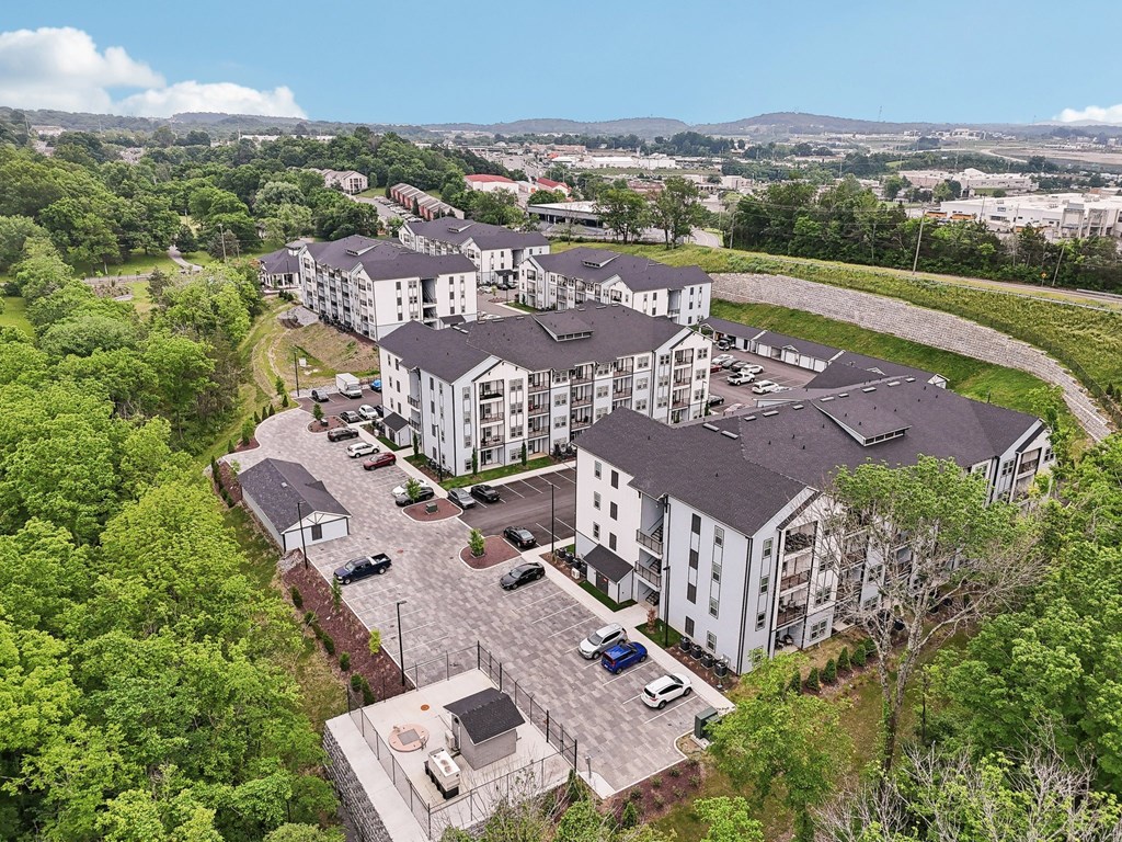A large white building surrounded by trees and a parking lot.