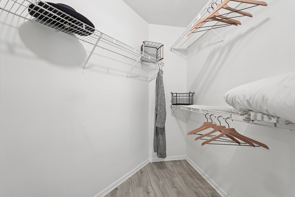 A white closet with a grey tie hanging in the middle.