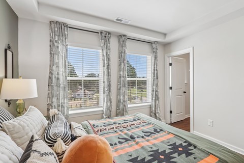 A bedroom with a large bed and a window with a view of the outside.