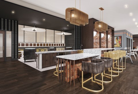 A modern bar with a white counter and gold chairs.